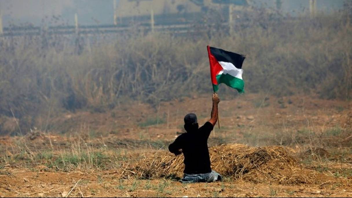 Ibrahim Abou Thouraya brandissant un drapeau palestinien lors d'affrontements avec les soldats israéliens dans la bande de Gaza, le 19 mai 2017.
