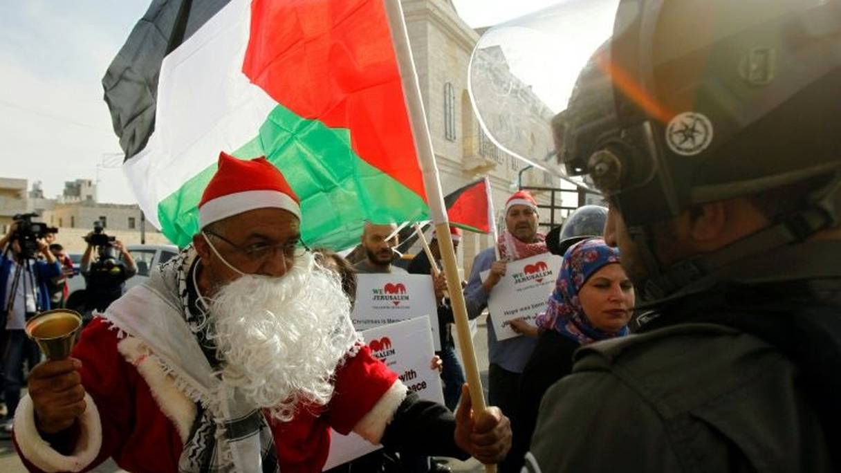Un manifestant palestinien habillé en père Noël s'oppose à un membre des forces de l'ordre israéliennes à Bethléem, en Cisjordanie occupée, le 23 décembre 2017.

