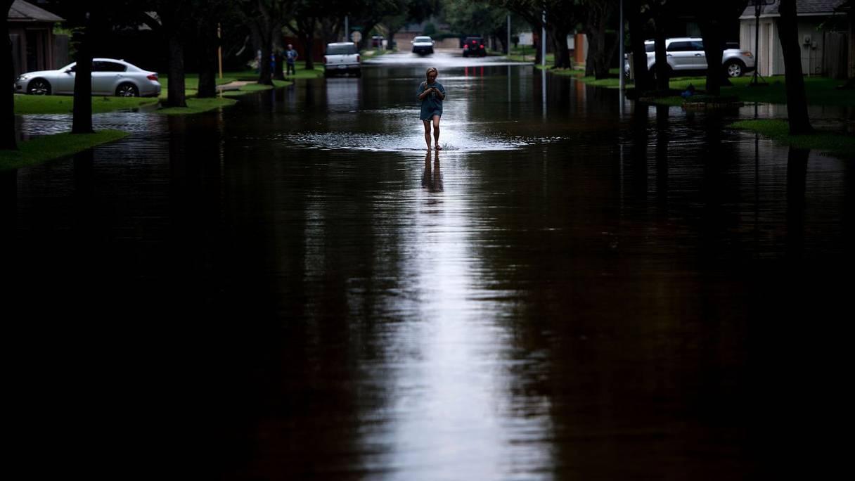 Une femme marche sur une route inondée après le passage d'Harvey le 30 août 2017. 
