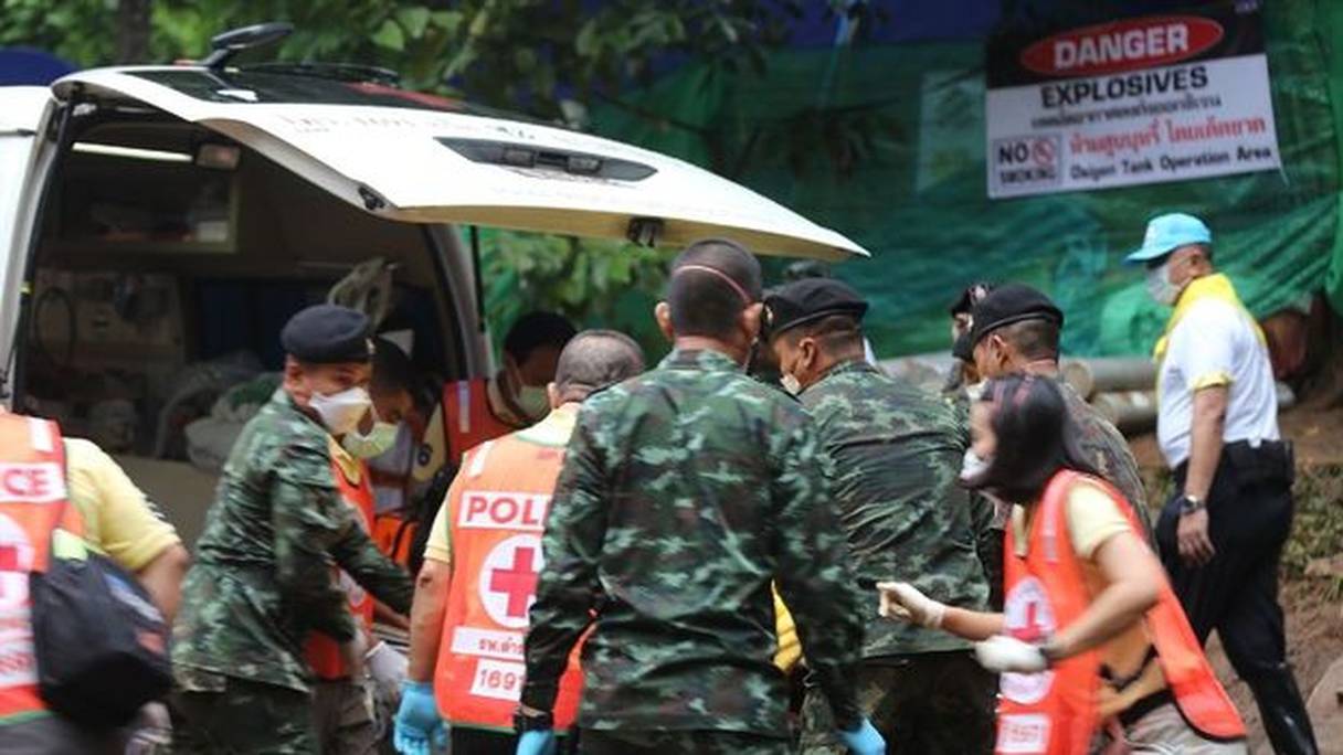 Des secouristes et des militaires thaïlandais installant un des enfants sauvés dans une amulance. 
