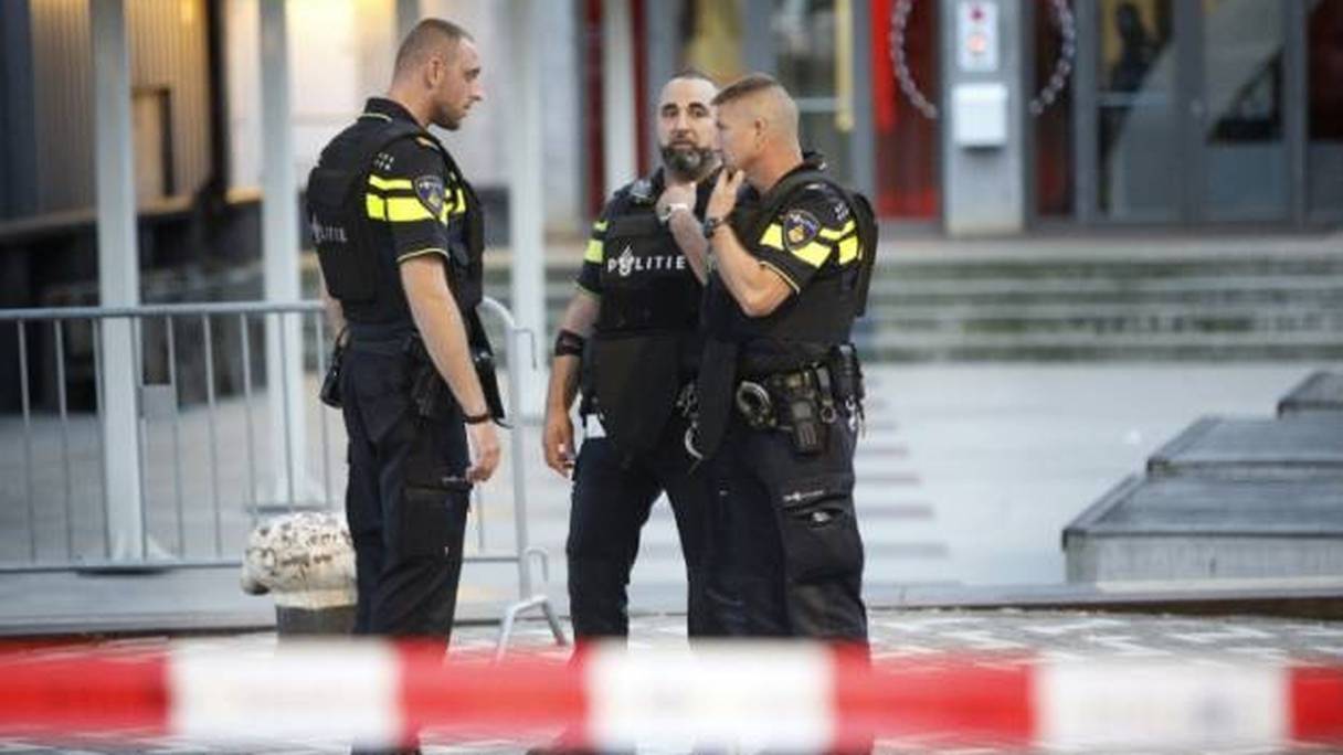 Des policiers discutent lors de l'évacuation de la salle de concert Maassilo à Rotterdam, après la découverte d'une camionnette contenant des bouteilles de gaz le 23 août 2017. 
