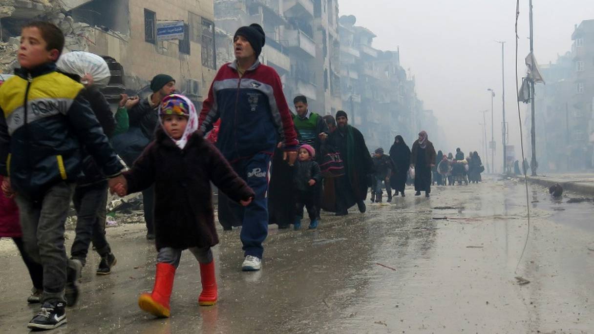 Des civils syriens quittent le 13 décembre 2016 le quartier de Boustane al-Qasr à Alep-Est.
