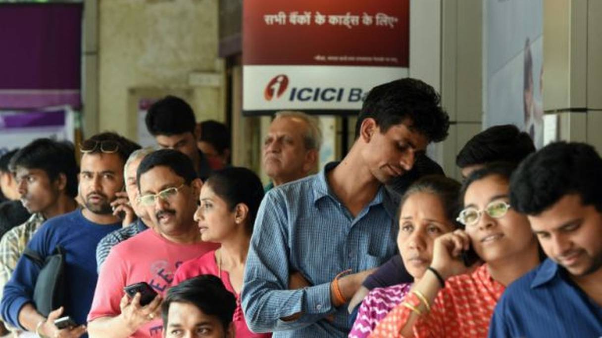 Des Indiens font la queue devant une banque à Bombay.
