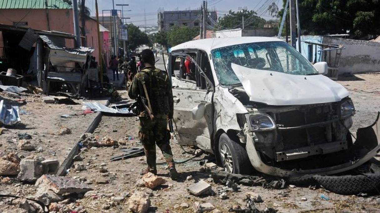 Un soldat près d'une voiture endommagée dans un attentat la bombe le 2 janvier 2017 à Mogadiscio. 
