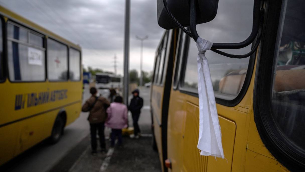 Un tissu blanc attaché au rétroviseur d'un bus. Des familles des territoires occupés par la Russie dans la région de Zaporizhzhia arrivent dans un convoi humanitaire dans un centre d'enregistrement et de traitement des personnes déplacées à Zaporizhzhia le 29 avril 2022.
