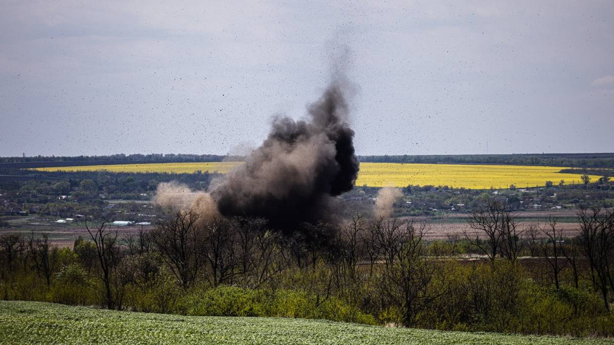 De la fumée monte après une explosion lors d'une mission de déminage par des membres d'une équipe de déminage du Service national d'urgence d'Ukraine, près du village de Hryhorivka, région de Zaporizhzhia, le 5 mai 2022, au cours de l'invasion russe de l'Ukraine.
