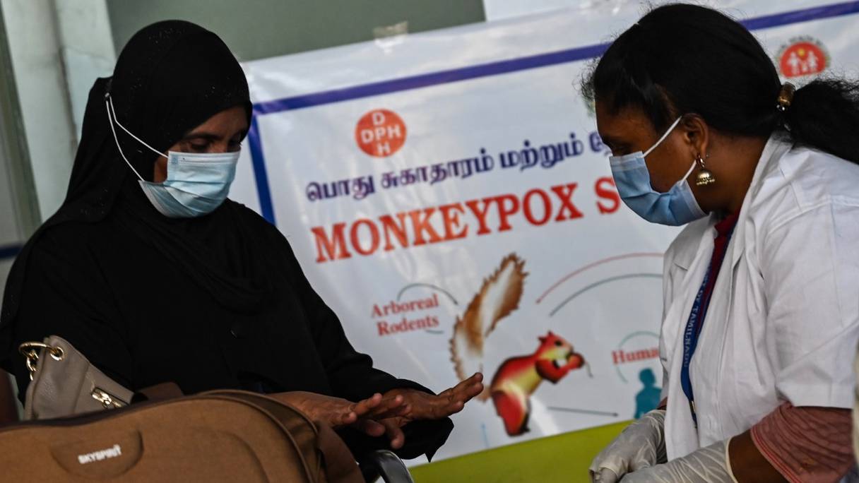 Des professionnels de santé examinent des passagers arrivant de l'étranger afin de détecter les symptômes de la variole du singe, au terminal de l'aéroport international d'Anna, à Chennai, en Inde, le 3 juin 2022.

