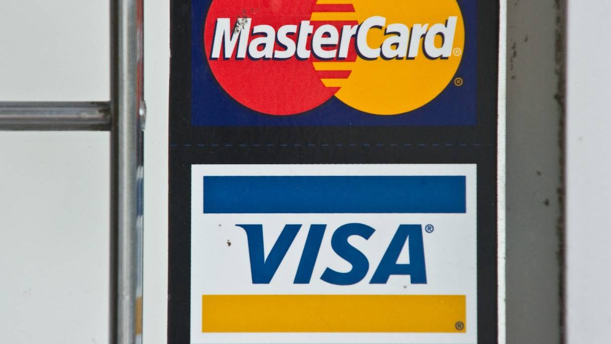 Logos des cartes de crédit Visa et MasterCard sont visibles, dans un magasin à Washington. Les géants du paiement par carte bancaire ont annoncé le 5 mars 2022 la suspension de leurs opérations en Russie.
