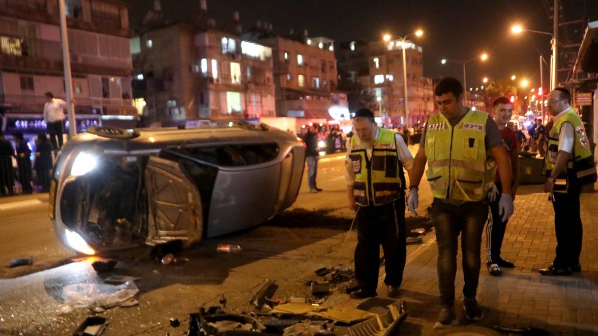 Un véhicule renversé gît sur la route sur les lieux d'une fusillade le 29 mars 2022 à Bnei Brak, à 7 km à l'est de Tel Aviv. Cinq personnes ont été tuées dans des attaques à l'arme à feu près de la ville côtière israélienne.
