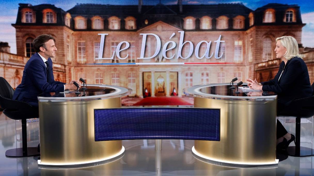 Emmanuel Macron et Marine Le Pen assis dans un plateau de télévision, juste avant leur débat retransmis en direct sur TF1 et France 2, le 20 avril 2022 au soir, à quatre jours du scrutin présidentiel du 24 avril 2022.
