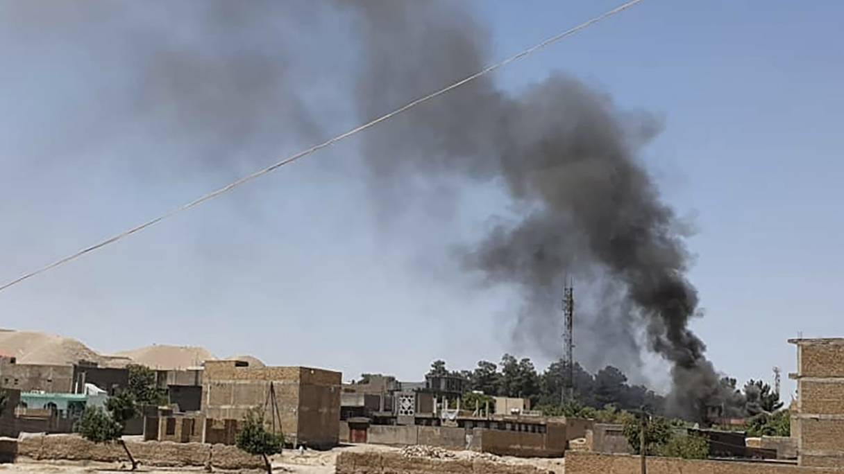 Un panache de fumée s'élève de maisons au milieu de combats en cours entre les forces de sécurité afghanes et les talibans dans la ville occidentale de Qala-i-Naw, dans la province de Badghis, le 7 juillet 2021. 
