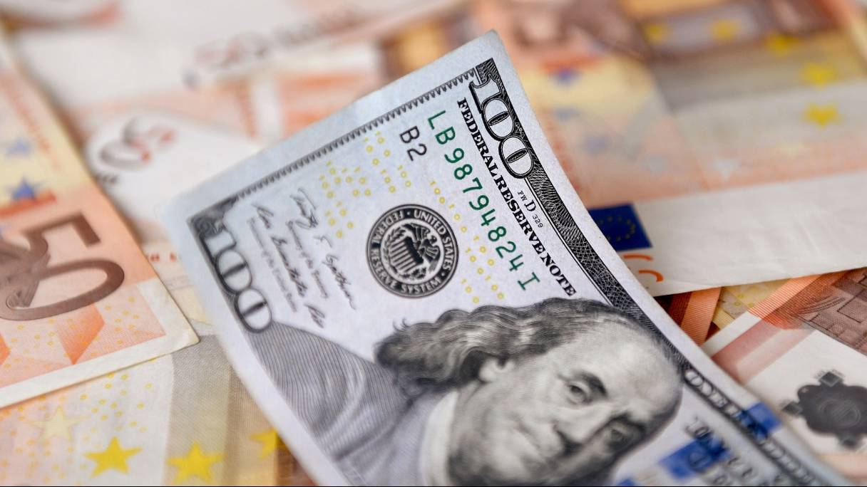 Un billet de 100 dollars et des billets en euros. L'euro a atteint la parité avec le dollar pour la première fois en près de 20 ans le 12 juillet 2022, alors qu'une réduction de l'approvisionnement en gaz russe vers l'Europe a accru les craintes de récession dans la zone euro.
