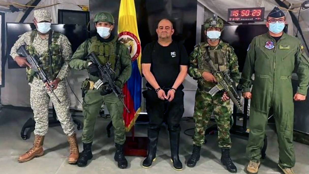 Des soldats de l'armée colombienne escortent le baron de la drogue le plus recherché du pays, Dairo Antonio Usuga (au centre) -dit Otoniel-, après sa capture, à Bogota, le 23 octobre 2021. Les Etats-Unis avaient offert une récompense de cinq millions de dollars pour sa capture.

