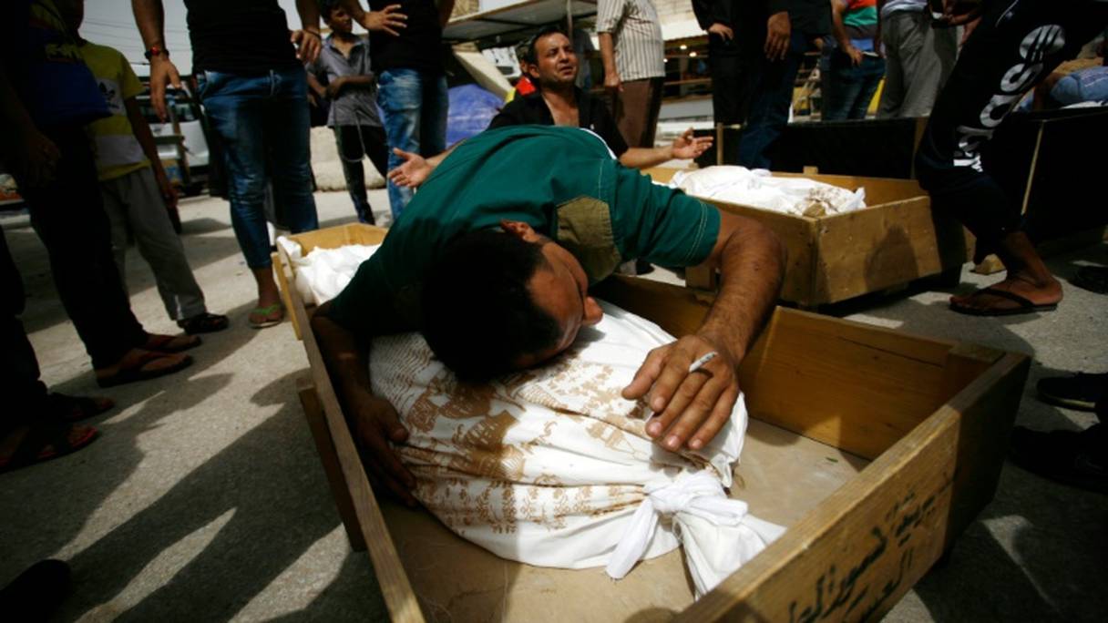 Des hommes pleurent sur les dépouilles de leurs proches, morts dans un attentat à Bagdad, lors de leurs funérailles à Najaf, le 3 juillet 2016.
