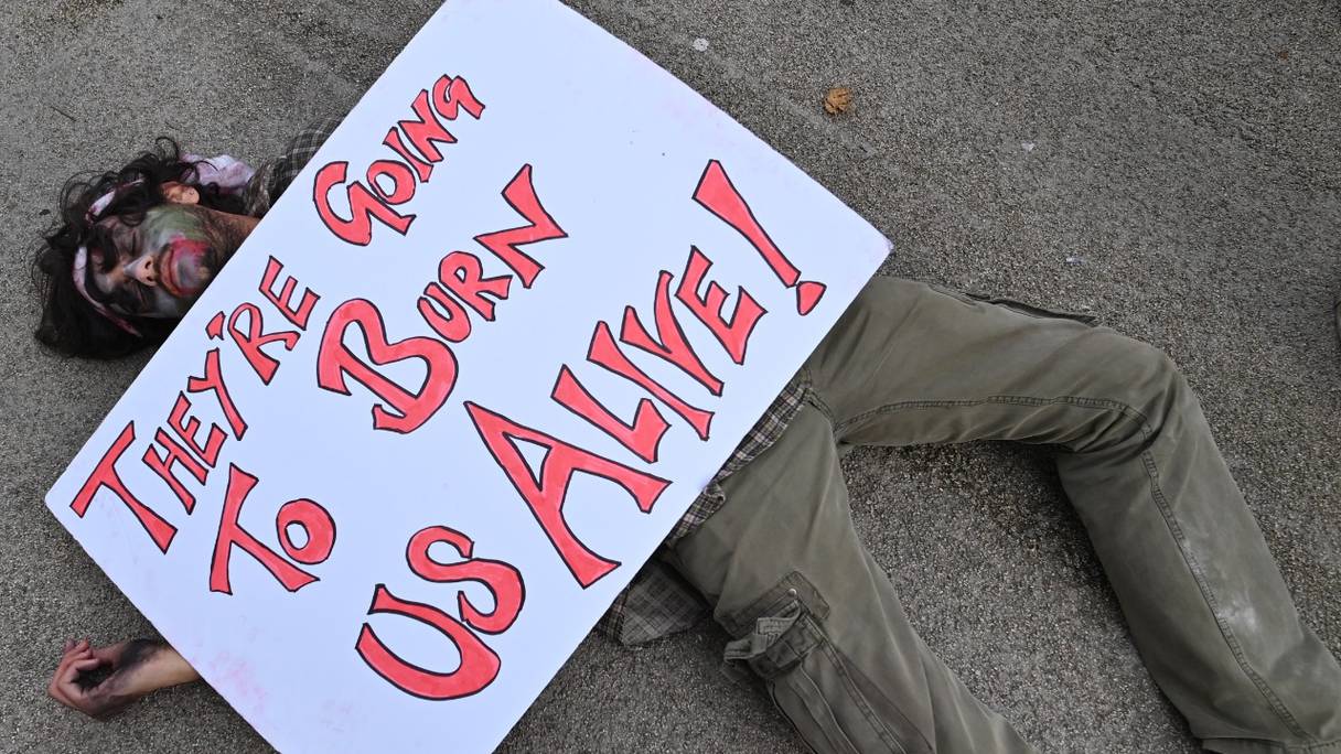 Des manifestants exécutent un "zombie die-in", lors d'une manifestation du groupe militant pour le climat Extinction Rebellion, à Glasgow, le 7 novembre 2021, lors de la Conférence des Nations Unies sur les changements climatiques (COP26).

