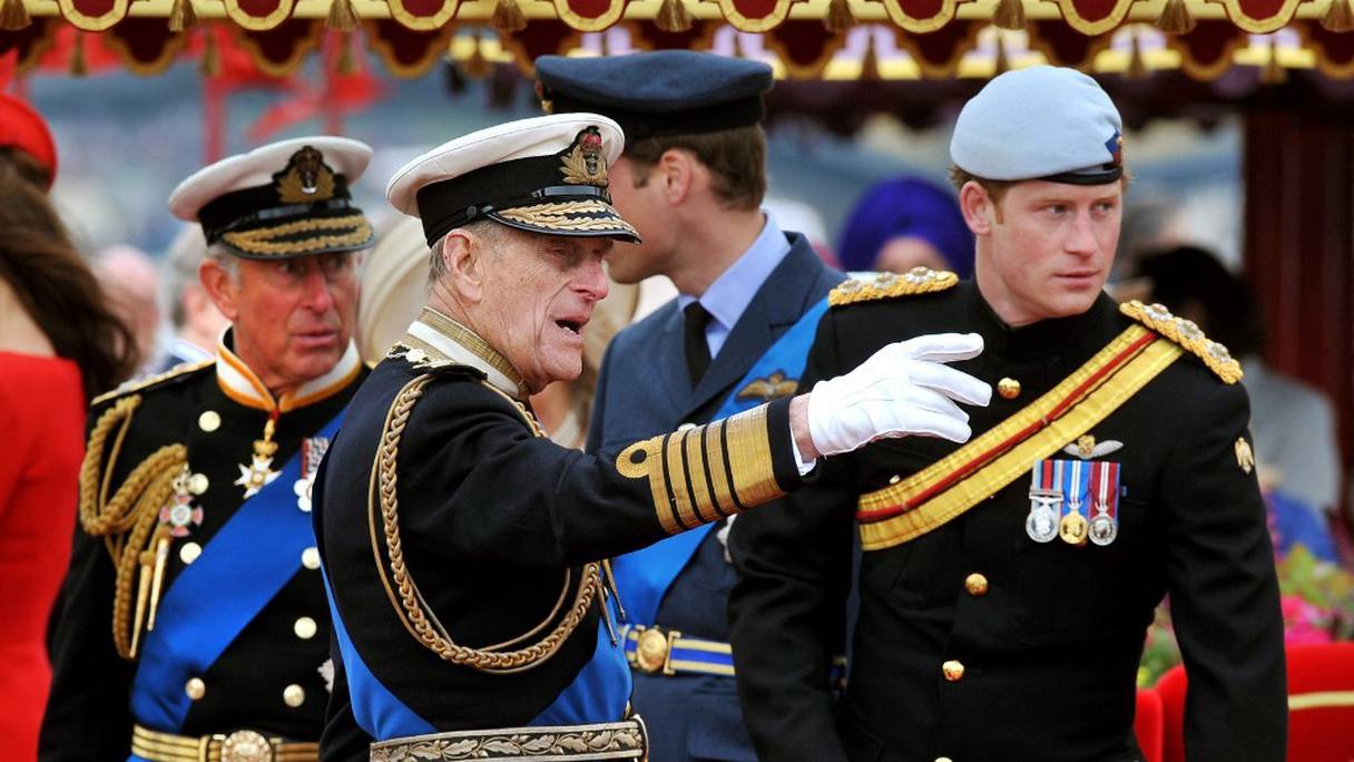 Le prince Philip, duc d'Edimbourg et le prince Harry, duc de Sussex, discutent à bord du Spirit of Chartwell pendant le jubilé de Diamant sur la Tamise, à Londres, le 3 juin 2012. Juste derrière eux, le prince Charles, prince de Galles, et le prince William, duc de Cambridge. 
