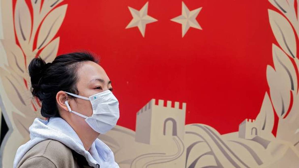 Une femme portant un masque sanitaire dans une rue de Pékin, le 2 mars 2020. 
