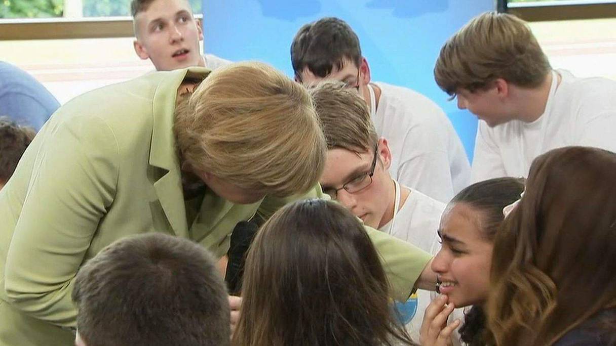 La chancelière allemande Angela Merkel voulant consoler la jeune Palestinienne. 

