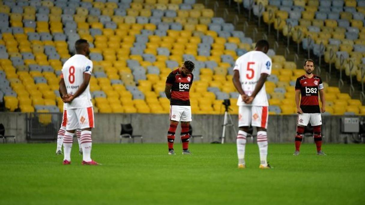 Les joueurs de Flamengo et Bangu observent une minute de silence en hommage aux victimes de la pandémie de Covid-19, le 18 juin 2020 à Rio de Janeiro.
