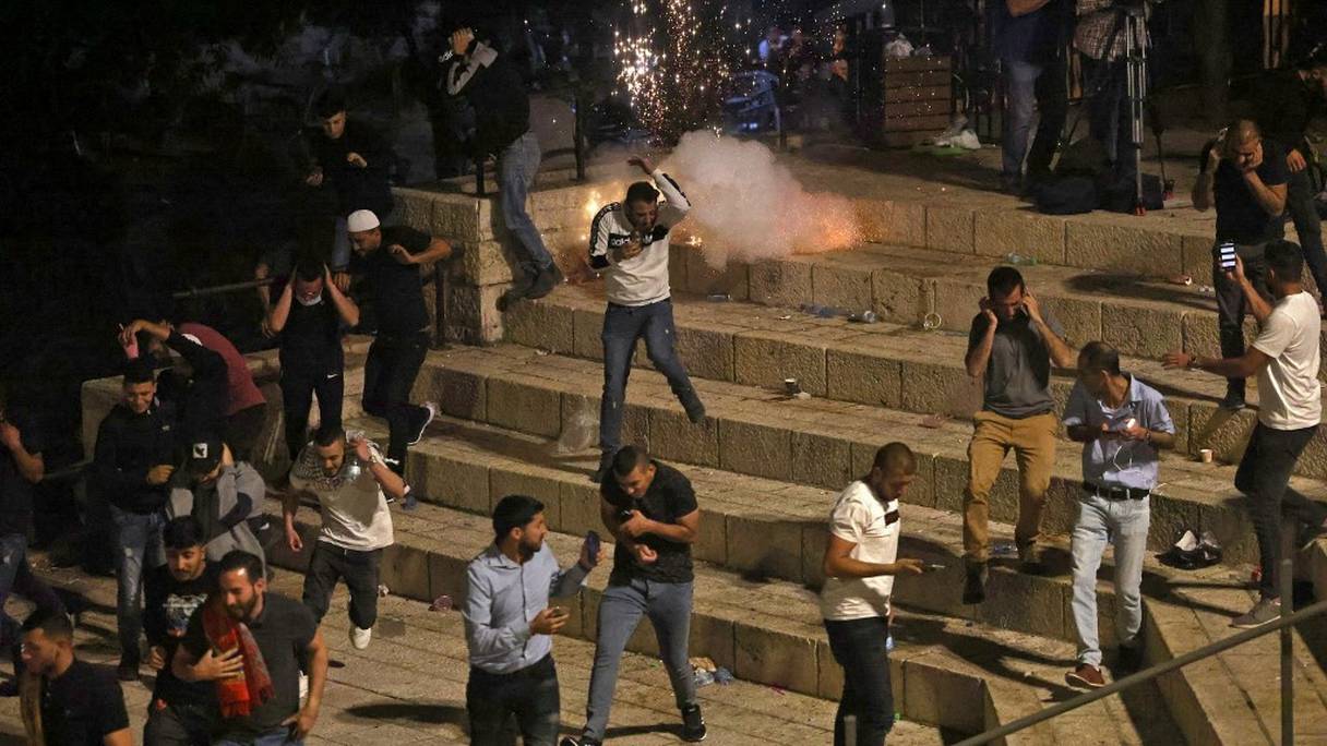 Des manifestants palestiniens fuient des grenades assourdissantes tirées par les forces de sécurité israéliennes devant la porte de Damas, dans la vieille ville de Jérusalem, le 8 mai 2021.
