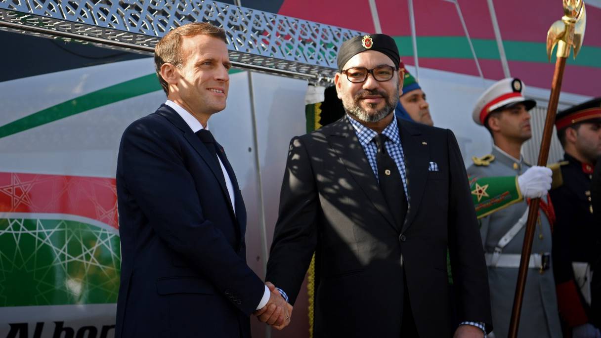 Le président français Emmanuel Macron (à gauche) et le roi du Maroc Mohammed VI (à droite) se serrent la main lors de l'inauguration d'une ligne à grande vitesse à la gare de Tanger le 15 novembre 2018.
