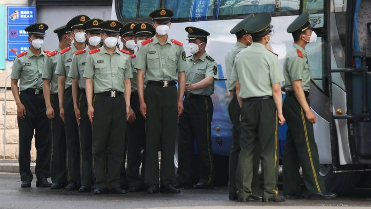 Des policiers chinois s'apprêtent à boucler les accès au marché Xinfadi de Pékin, le 13 juin 2020.
