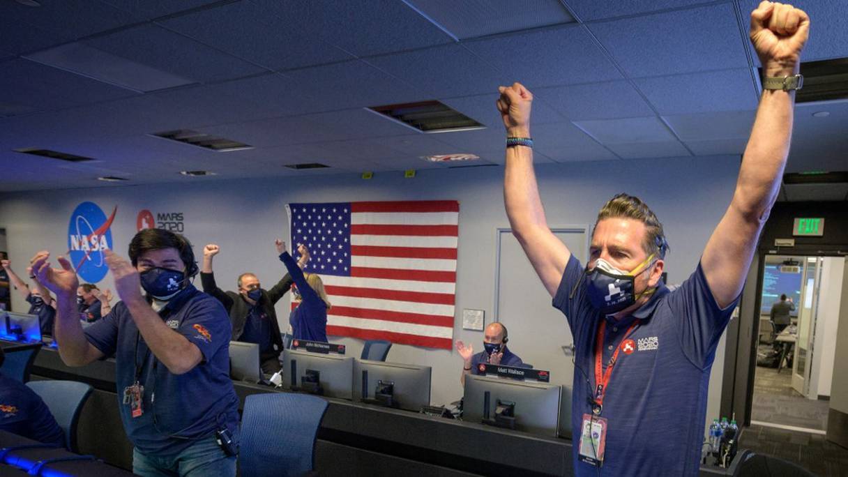 Des membres de l'équipe du rover Perseverance de la NASA expriment leur joie après avoir reçu la confirmation que le vaisseau spatial a atterri avec succès sur Mars, le 18 février 2021, au Jet Propulsion Laboratory de la NASA à Pasadena, en Californie. 
