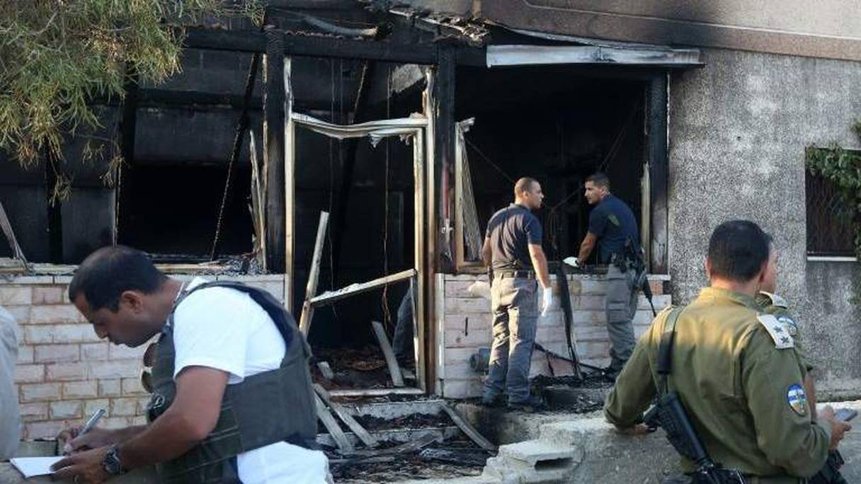 Des enquêteurs devant la maison palestinienne, cible d'un incendie criminel dans le village de Doma, ce vendredi 31 juillet 2015.
