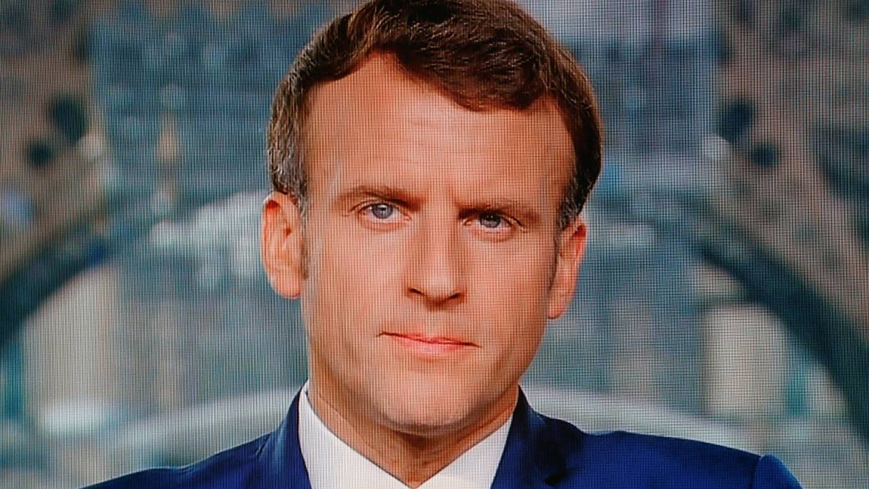 Le président français Emmanuel Macron est photographié depuis un écran de télévision, alors qu'il s'exprime lors d'une allocution télévisée à la nation, à Paris le 12 juillet 2021.
