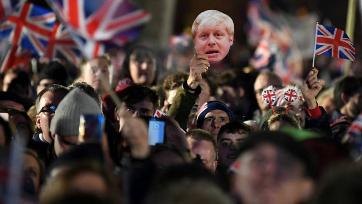 Des partisans du Brexit agitent des drapeaux britanniques et un masque du Premier ministre Boris Johnson à Londres le 31 janvier 2020.

