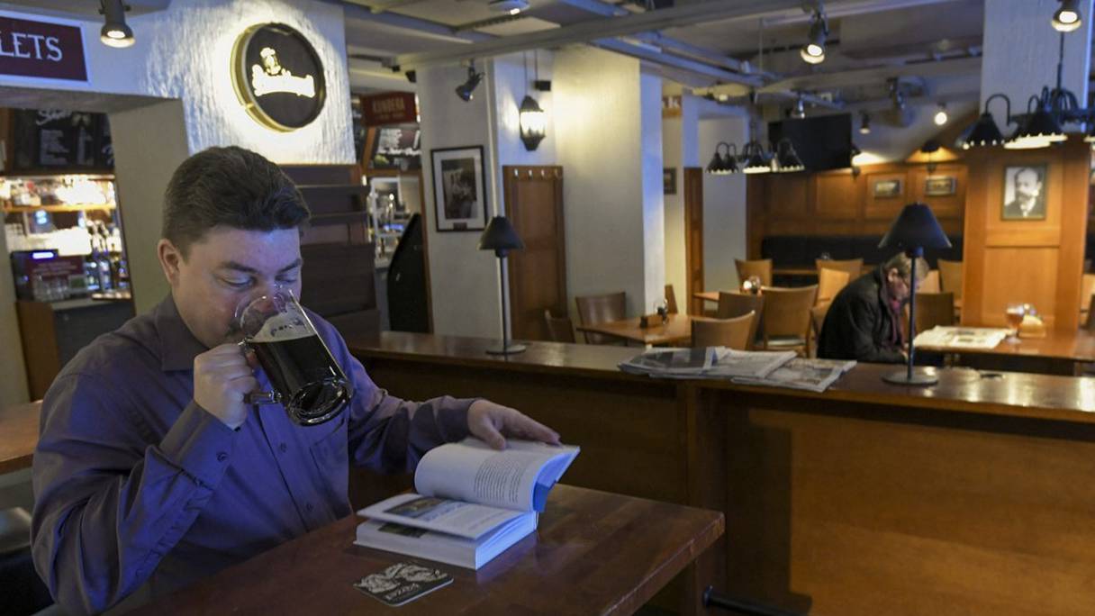 Des clients dégustent leur bière dans un pub de style tchèque, Vltava, dans le centre-ville d'Helsinki, en Finlande, le 7 mars 2021, un jour avant le début de restrictions partielles de trois semaines, pour les zones les plus touchées par le coronavirus.
