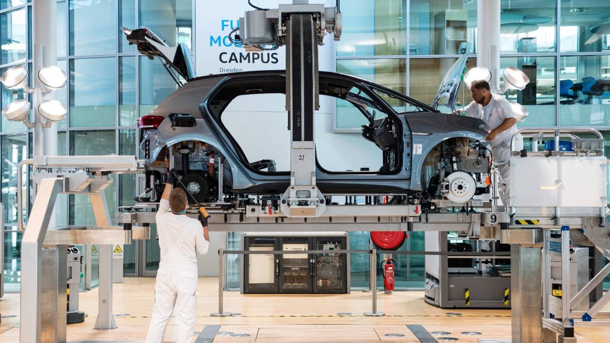 Des ouvriers travaillent sur la chaîne de montage de la voiture électrique Volkswagen ID 3 du constructeur automobile allemand Volkswagen, sur le site de production de la Glaeserne Manufaktur, à Dresde, dans l'est de l'Allemagne, le 8 juin 2021.
