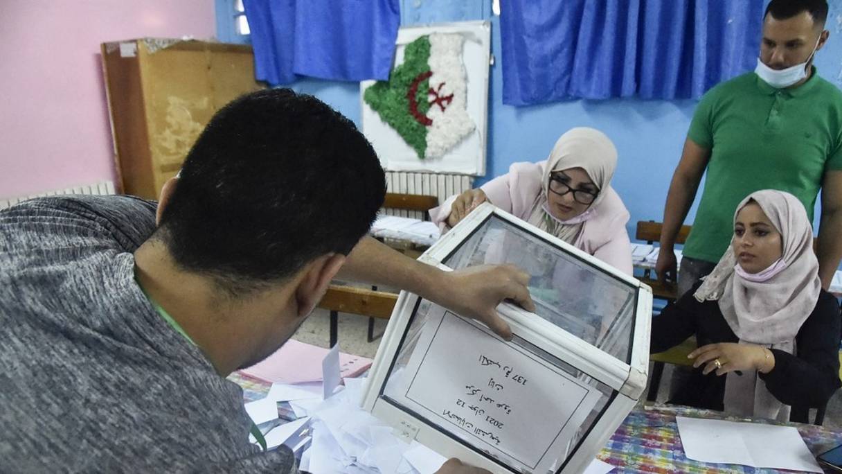 Le personnel électoral algérien compte les bulletins de vote pour les élections législatives dans un bureau de vote à Bouchaoui, à la périphérie ouest de la capitale, Alger, le 12 juin 2021.
