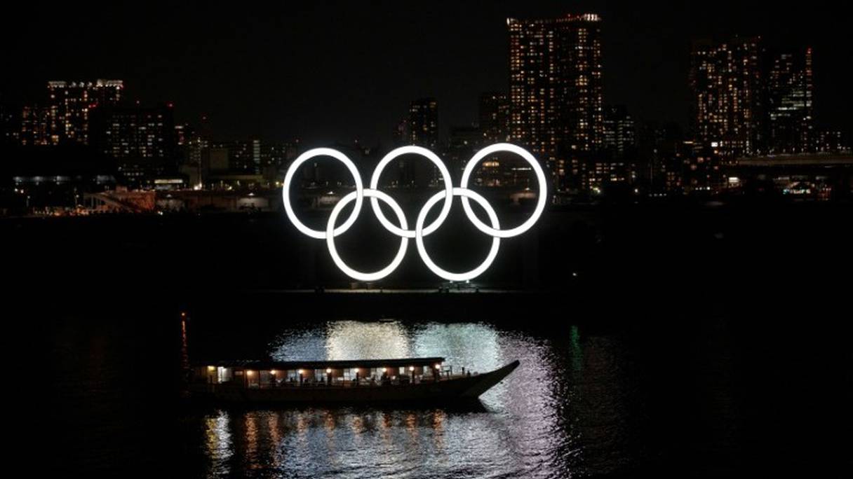 Les anneaux olympiques se reflètent dans l'eau dans le district d'Odaiba le 23 mars 2020.
