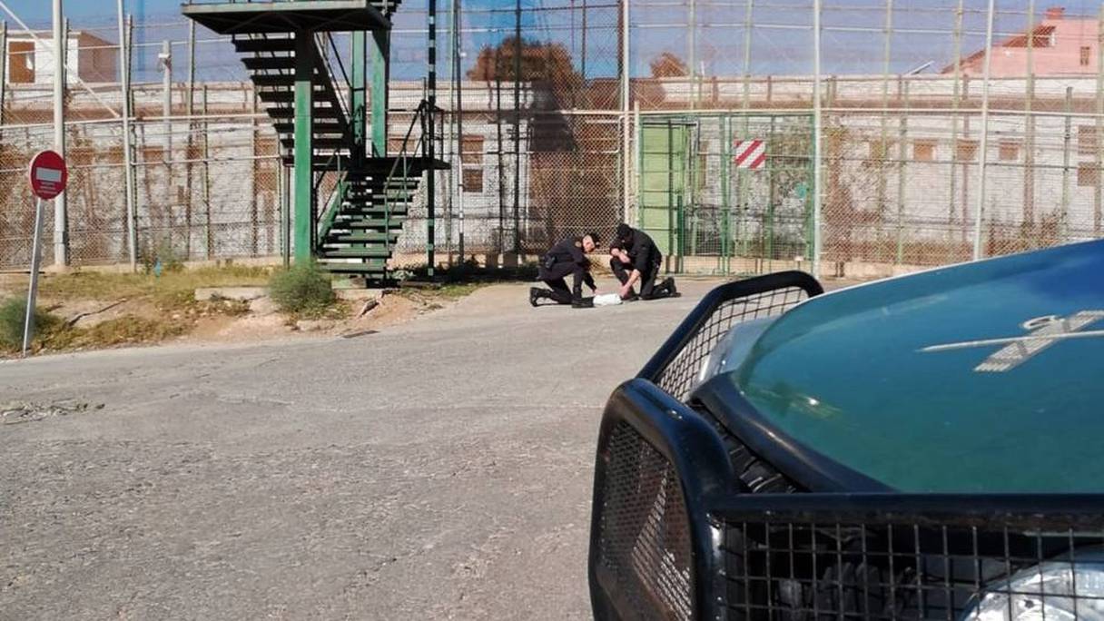 Des agents de la Guardia Civil devant la clôture de la frontière entre le Maroc et le préside occupé.
