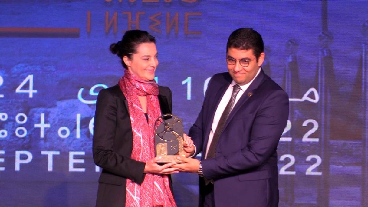 Mehdi Bensaïd, ministre de la Culture, remet un trophée à titre posthume en l'honneur de l'œuvre accomplie par Nour Eddine Saïl, à Nadia Larguet, qui fut son épouse, au cours de la cérémonie d'ouverture du festival national du film de Tanger, le 16 septembre 2022.
