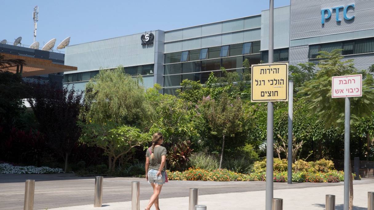 Une femme marche devant le bâtiment abritant le groupe israélien NSO, à Herzliya, près de Tel Aviv. L'entreprise israélienne est accusée par plusieurs médias de fournir des logiciels espions à des gouvernements, dont le Maroc. 
