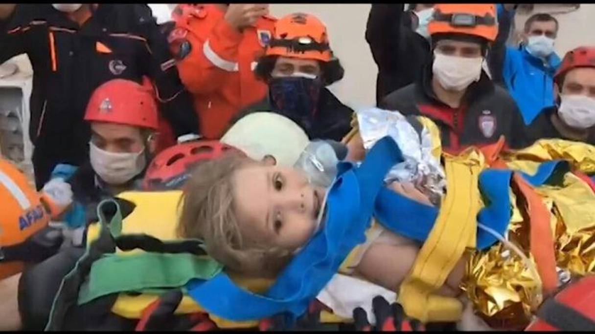Drapée d'une couverture de survie en aluminium, la fillette a été évacuée sur une civière vers un hôpital, mardi 3 novembre 2020, à Izmir. 
