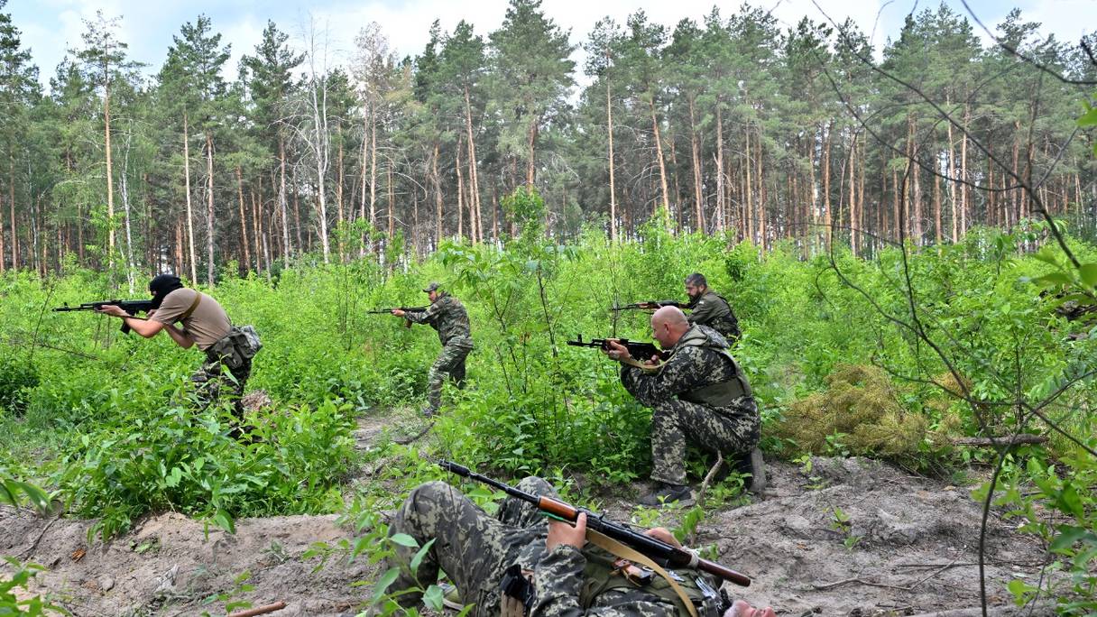 Des combattants de l'unité de défense territoriale, une force de soutien à l'armée régulière ukrainienne, participent à un exercice dans le cadre des classes régulières de tactiques de combat, non loin de Bucha, dans la région de Kiev, le 17 juin 2022.
