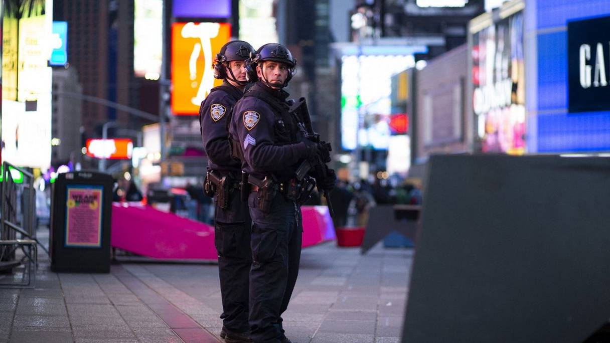 Des agents de la police new-yorkaise montent la garde après que deux femmes et une fillette de quatre ans ont été blessées par des tirs d'armes à feu à Times Square, à New York, le 8 mai 2021. 
