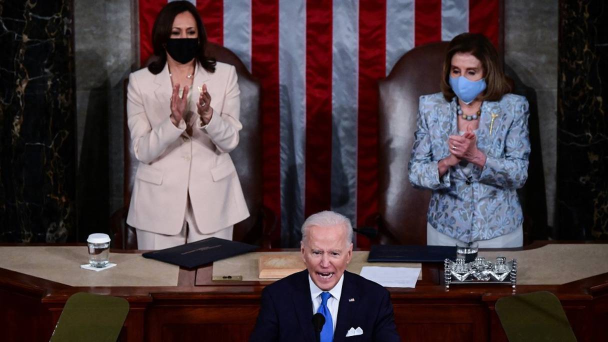 Le président américain Joe Biden s'adresse aux membres du Congrès, alors que la vice-présidente américaine Kamala Harris et la présidente américaine de la Chambre Nancy Pelosi l'applaudissent, au Capitole américain, à Washington, le 28 avril 2021.

