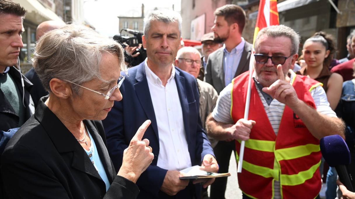 La Première ministre française Elisabeth Borne est interpellée par un syndicaliste CGT alors qu'elle distribue des tracts, en tant que candidate à la troisième circonscription des Côtes d'Armor, dans le cadre de la campagne pour les élections législatives, le 9 juin 2022.
