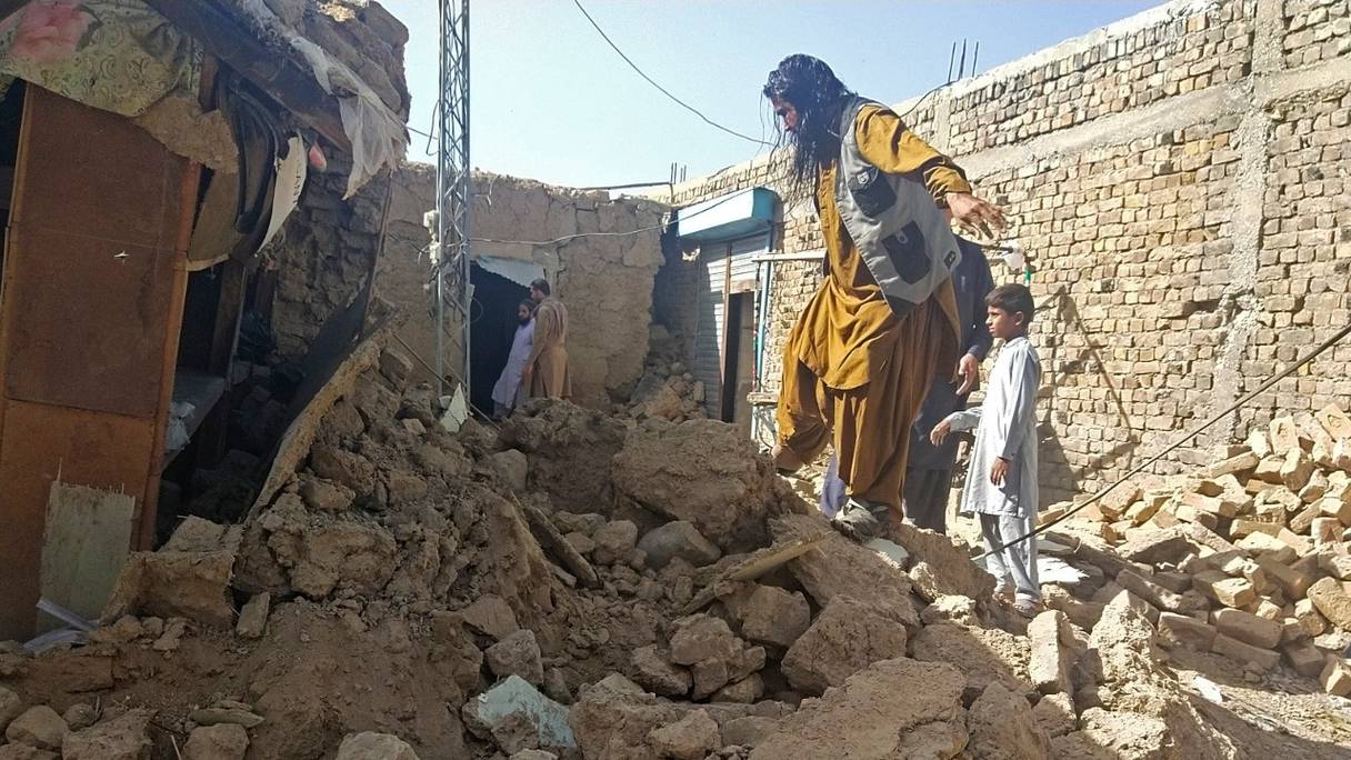 Des habitants, à côté des débris de leur maison effondrée suite à un séisme à Harnai, le 7 octobre 2021. Environ 20 personnes ont été tuées et plus de 200 blessées dans le sud-ouest du Pakistan aux premières heures du 7 octobre.
