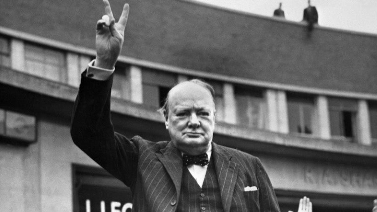 Winston Churchill faisant le V de la Victoire à Londres, à la fin de la Seconde guerre mondiale (photographie non datée). 
