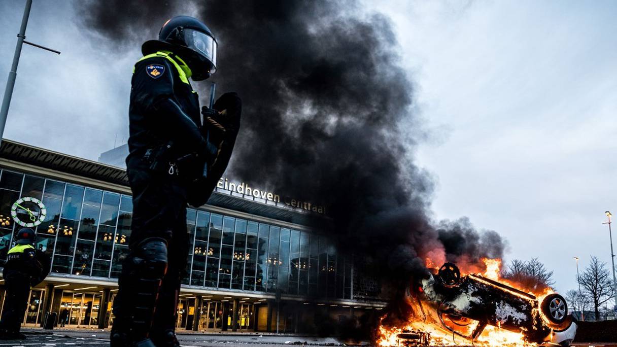 Un véhicule a été incendié devant la gare d'Eindhoven, après un rassemblement de plusieurs centaines de personnes contre la politique anti-coronavirus, le 24 janvier 2021 aux Pays-Bas. 
