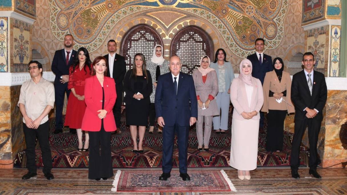 Au centre, le président algérien Abdelmadjid Tebboune entouré des journalistes, à l'occasion de la 7e édition du prix du président de la République du journaliste professionnel. Le 23 octobre 2021, au palais du Peuple, à Alger.
