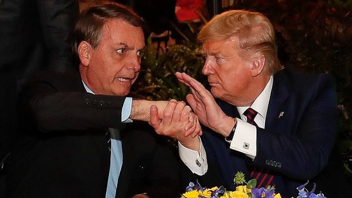 Jair Bolsonaro serrant la main de Donald Trump lors d'un dîner, samedi 7 mars dernier.

