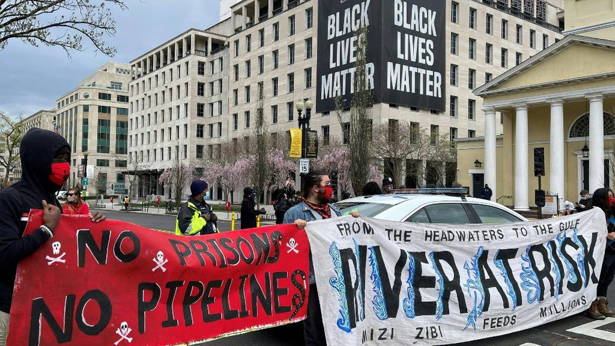 Des militants écologistes manifestent avec des banderoles, réclamant la fermeture d'oléoducs du nord des Etats-Unis, au Black Lives Matter Plaza à Washington, le 1er avril 2021.
