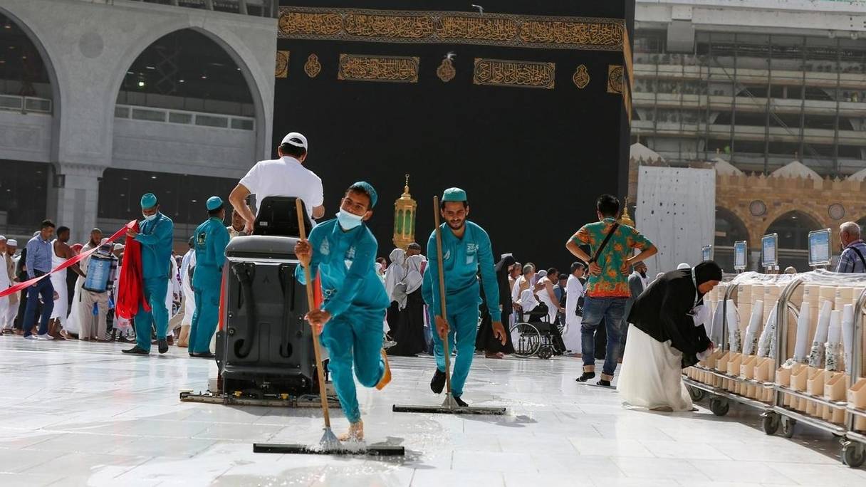 A la Kaaba, dans la grande mosquée de La Mecque, en Arabie Saoudite, des agents de nettoyage portent des masques de protection, le 3 mars 2020.
