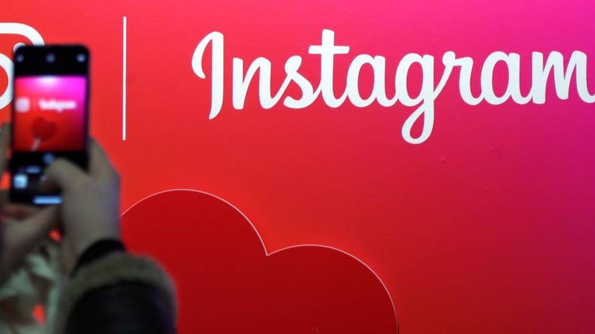 Une utilisatrice d'Instagram prend le logo en photo à Paris, le 7 février 2018.
